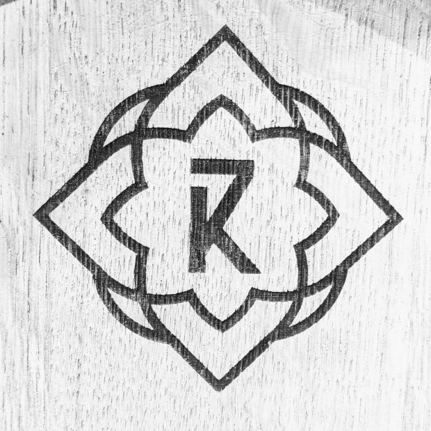 A geometric flower shape that is the logo of 7K Distillery